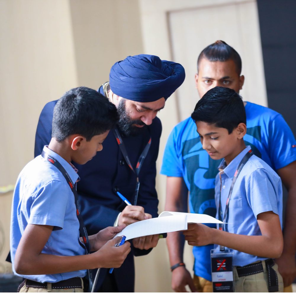Harjeet signing autographs for young students