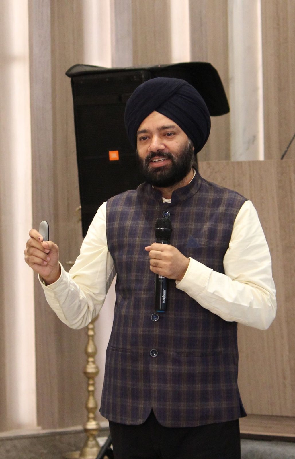 Harjeet Khanduja speaking with a microphone and clicker