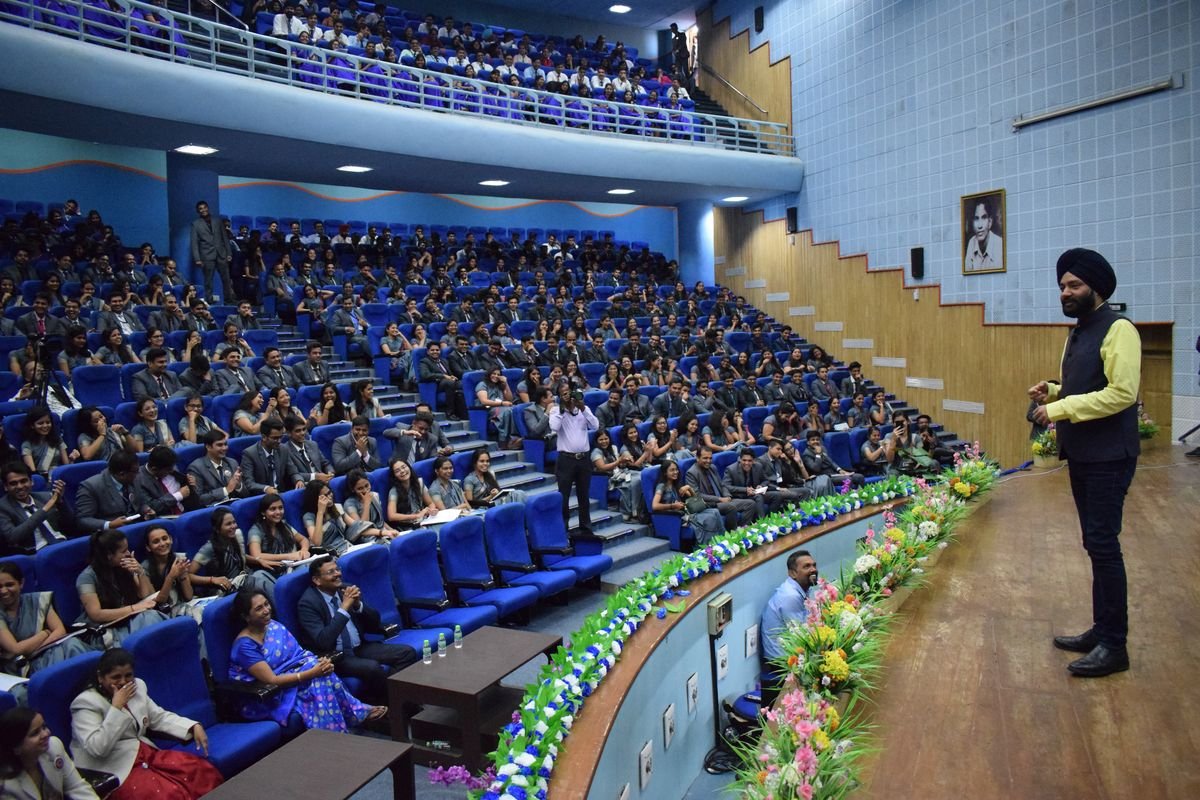 Harjeet addressing a full auditorium of management students