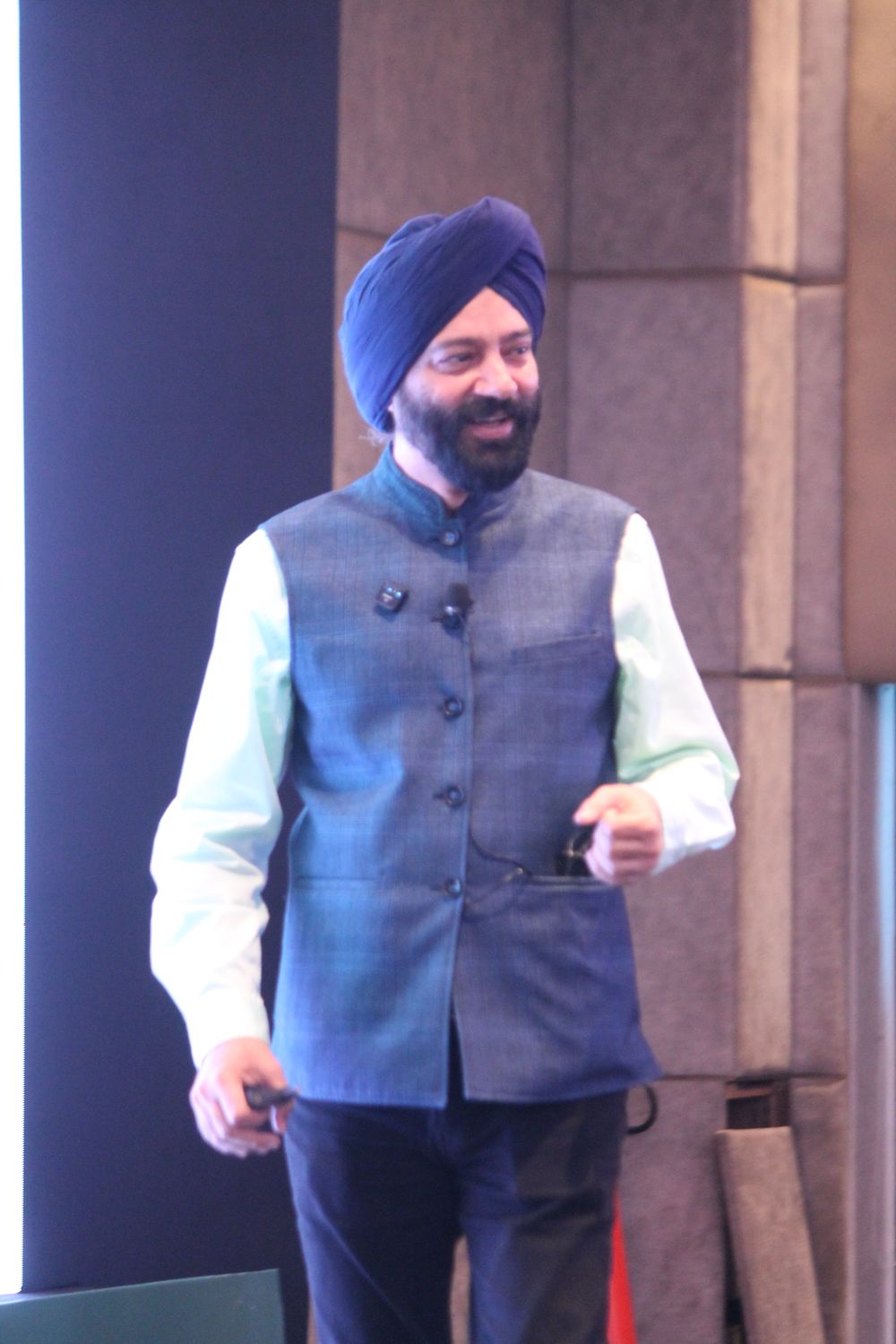 Harjeet walking the stage during a session